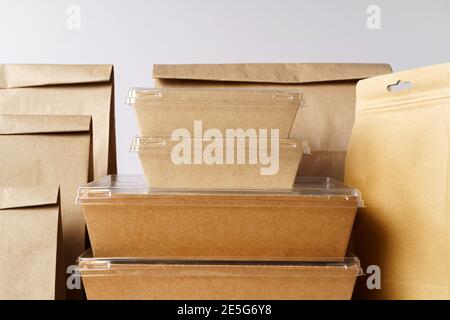 Viele verschiedene Take-out-Food-Container, Pizzakasten, Kaffeetassen und Papiertüten auf hellgrauem Hintergrund Stockfoto