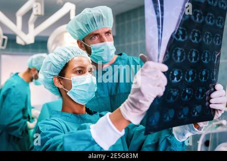 Team von Chirurgen Ärzte Blick auf Röntgenfilm vor der Operation Zum Einrichten der Diagnose Stockfoto