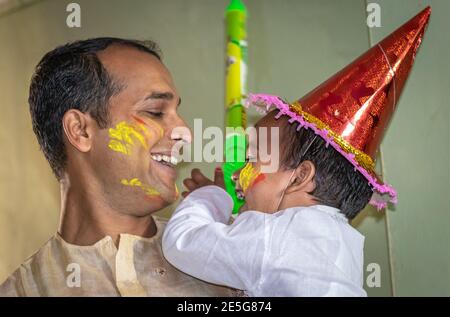 Vater und Tochter genießen die holi Feier das Festival der Farben Nahaufnahme ist der Ausdruck des Kindes beim Genießen der indischen holi. Es ist Stockfoto