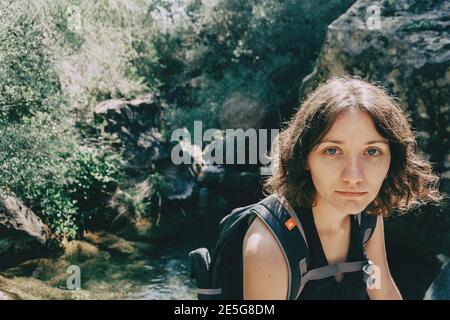 Mädchen, das in den Bergen von Prades, Tarragona, Spanien mit Blick auf die Kamera sitzt Stockfoto