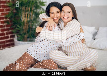 Zwei junge Mädchen im Schlafanzug umarmt einander und suchen Glücklich Stockfoto