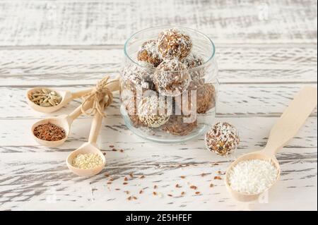 Hausgemachte natürliche Energiebisse, vegane Schokoladentrüffel mit Kakao und Kokosnuss auf weißem Hintergrund. Gesunde Lebensmittel für Kinder, Süßigkeiten Ersatz Stockfoto