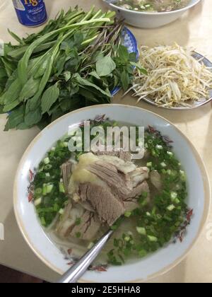 Schüssel vietnamesische Pho Nudelsuppe mit Rind und Kräutern Stockfoto