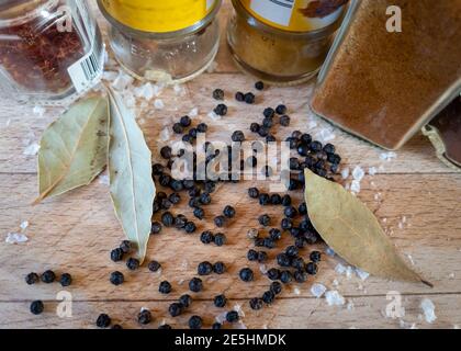 Eine Auswahl an Kochgewürzen auf einer Holzplatte. Stockfoto