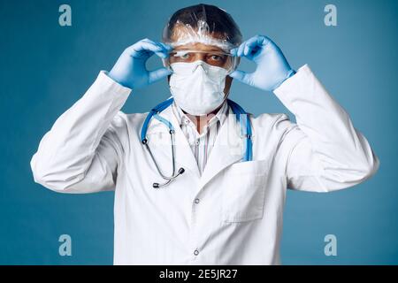 Arzt in Schutzkleidung auf blauem Hintergrund. Stockfoto