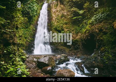 Mächtiger Wasserfall und Felsen mit Steinen. Wasserfall in Bali, Indonesien Stockfoto