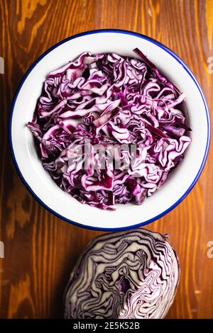 Frisch geschnittener Rotkohl in Schüssel auf Holztisch. Draufsicht. Stockfoto