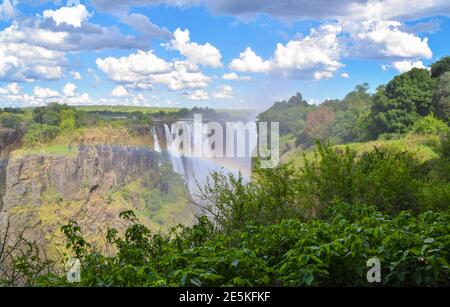 Der ikonische Mosi-OA-Tunya Wasserfall alias Victoria Falls mit Regenbogen. Blick von der Simbabwe-Seite. Stockfoto