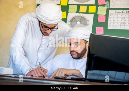 ein araber überprüft die Arbeitsergebnisse mit seinem Manager Stockfoto