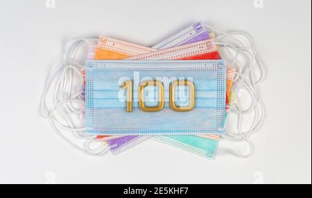 Nummer 100 über medizinische Einwegmasken. Color Surgical Mask. Einhaltung des Regimes des dauerhaften Tragens der Maske Stockfoto