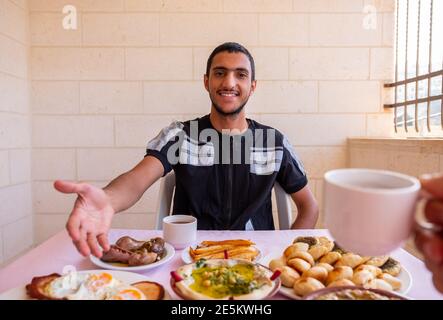 Der muslimische Mann begrüßt andere, um sich ihm anzuschließen Stockfoto