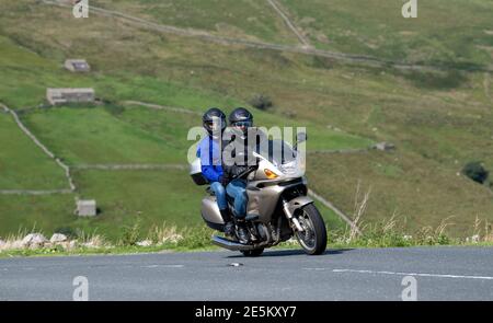 Motorradfahrer mit Sozius fahren über den Buttertubs Pass zwischen Muker und Hawes im Yorkshire Dales National Park, Großbritannien. Stockfoto