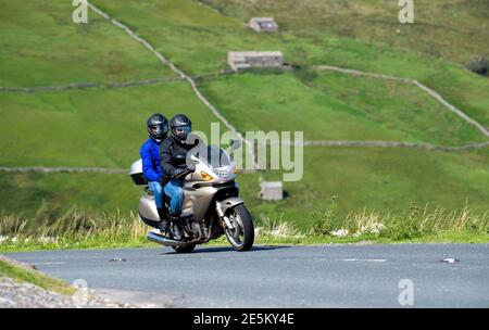 Motorradfahrer mit Sozius fahren über den Buttertubs Pass zwischen Muker und Hawes im Yorkshire Dales National Park, Großbritannien. Stockfoto