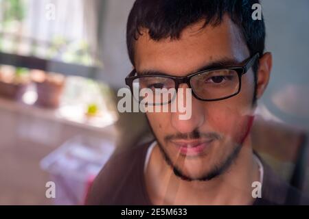 Guy verloren in seinen Gedanken hinter Glas Fenster Stockfoto