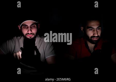 Portrait von Jungs aus dem Nahen Osten, die in einem Dunkeln zusammengehen Zimmer Stockfoto