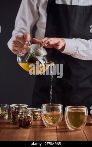 Teemeister gießt grünen Tee in Glas Tassen von einem Topf Stockfoto