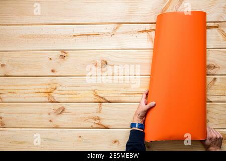 Hände Abrollen bunte Vinyl Rollen auf Holz Hintergrund Stockfoto