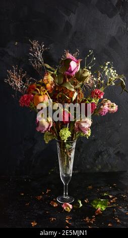Ein Bouquet von getrockneten Blumen in einer Kristallvase auf schwarzem Hintergrund. Stockfoto