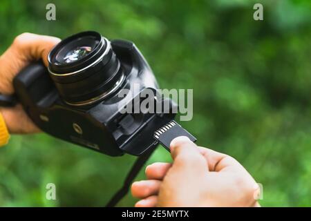 Fotograf, der die Speicherkarte in die Kamera einsteckt Stockfoto