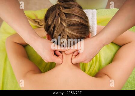 Klassische Hals- und Schultermassage. Schöne Frau genießt eine Behandlung in einem Spa-Center. Körper- und Gesundheitskonzept. Stockfoto