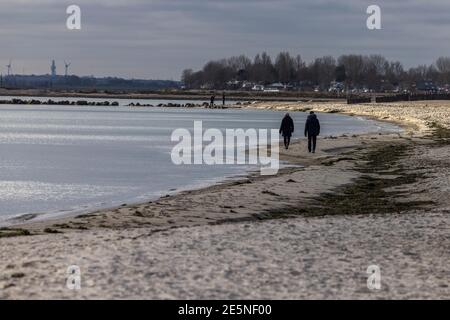 Insel Fehmarn, Deutschland. Januar 2021. Zwei Leute laufen am Südstrand in der Sonne. Kredit: Frank Molter/dpa/Alamy Live Nachrichten Stockfoto