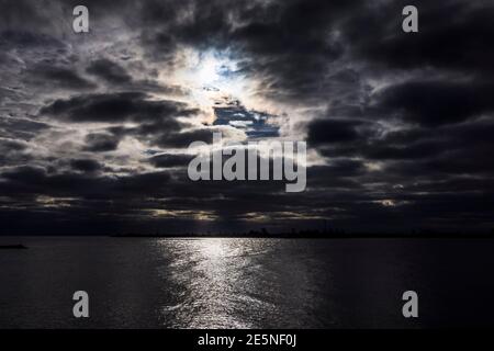 Insel Fehmarn, Deutschland. Januar 2021. Die Sonne bahnt sich ihren Weg durch dunkle Wolkenfelder über der Ostsee. Kredit: Frank Molter/dpa/Alamy Live Nachrichten Stockfoto