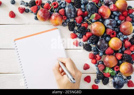 Einkaufsliste mit gemischtem Obst und Zutaten mit Pflaume, Himbeere, Heidelbeere, Brombeere aus der Draufsicht Stockfoto