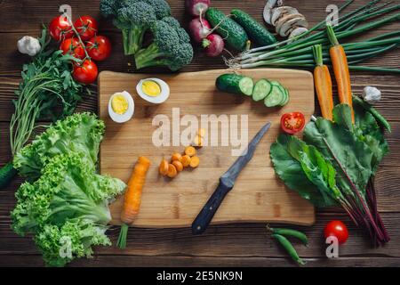 Gesunde Lebensmittel und Zutaten mit Tomate auf rustikalem Holzhintergrund, Draufsicht Stockfoto