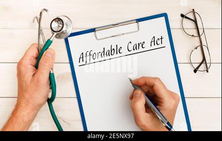 Papier mit ACA Affordable Care Act auf dem Bürotisch und Stethoskop. Medizinisches Konzept. Stockfoto