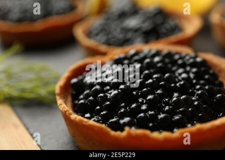 Tartlets mit schwarzem Kaviar auf Schneidebrett, Nahaufnahme Stockfoto