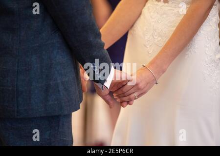 Nahaufnahme einer Braut und Bräutigam halten Hände während Hochzeitszeremonie Stockfoto