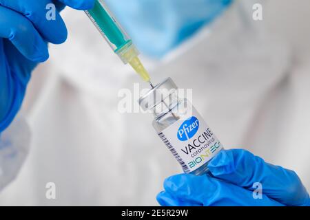 Pfizer und BioNTech Coronavirus-Impfstoff und Spritze in der Flasche oder im Fläschchen zur Injektion in die Hände des Arztes. Covid-19, SARS-Cov-2 Prävention, Januar Stockfoto