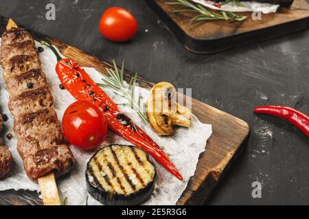 Gegrillter Lula Kebab auf Spieße auf Holzbrett serviert Stockfoto