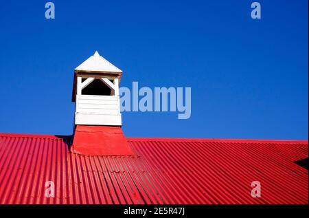 Helles rot lackiertes Kirchendach aus Wellblech auf blauem Himmel Hintergrund Stockfoto