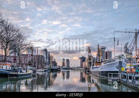 Rotterdam, Niederlande, 13. Januar 2021: Spektakulärer Himmel bei Sonnenaufgang über dem Hafen von Leuvehaven mit historischen Booten und Schiffen