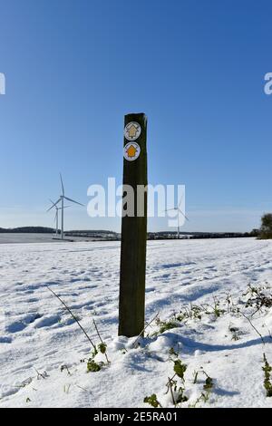 Öffentlicher Fußweg Pfeilzeichen auf einem Pfosten an einem öffentlichen Recht des Weges über Farmland im Schnee in der Nähe von Emberton, Olney und Milton Keynes Bucks. Stockfoto