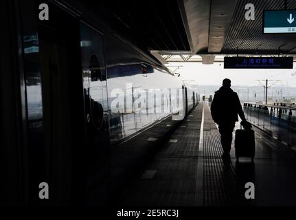 (210128) -- SHANGHAI, 28. Januar 2021 (Xinhua) -- Gao Li bereitet sich darauf vor, am Shanghai Hongqiao Bahnhof in Shanghai, Ostchina, am 28. Januar 2021 in einen Zug zu steigen. Am ersten Tag des Frühlingsfests im Jahr 2021 packte Gao Li, ein Wanderarbeiter nach den 90er Jahren in Shanghai, sein Gepäck und machte sich auf den Weg zurück in seine Heimatstadt Huangpi, Wuhan in Zentralchina, zum Frühlingsfest. Vor dem Einchecken fummelte er nach dem negativen Nukleinsäuretestbericht in seiner Tasche. Nichts könnte wichtiger sein als dieses Gepäckstück. Vor zwei Tagen kamen medizinische Arbeiter aus Shanghai nach GA Stockfoto