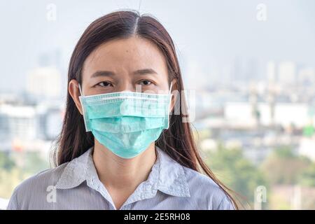 Asiatische Frau trägt hygienische schützen Gesichtsmaske COVID-19, Coronavirus-Infektion zu verhindern, während außerhalb von zu Hause während covid Virus-Epidemie Übertragung Stockfoto