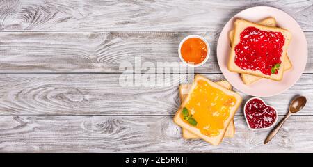 Leckere Toasts mit verschiedenen süßen Marmeladen auf grauem Hintergrund. Copyspace für Ihren Text, Banner Stockfoto