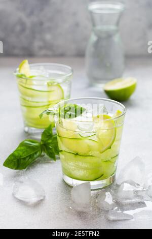 Erfrischende Sommer hausgemachte Limonade aus Limette, Zitrone, Gurke und Basilikum mit Eis im Glas auf altem Beton Hintergrund. Selektiver Fokus. Stockfoto