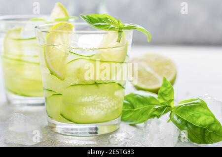 Erfrischende Sommer hausgemachte Limonade aus Limette, Zitrone, Gurke und Basilikum mit Eis im Glas auf altem Beton Hintergrund. Selektiver Fokus. Stockfoto