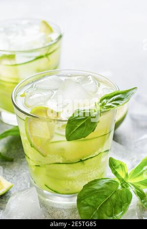 Erfrischende Sommer hausgemachte Limonade aus Limette, Zitrone, Gurke und Basilikum mit Eis im Glas auf altem Beton Hintergrund. Selektiver Fokus. Stockfoto