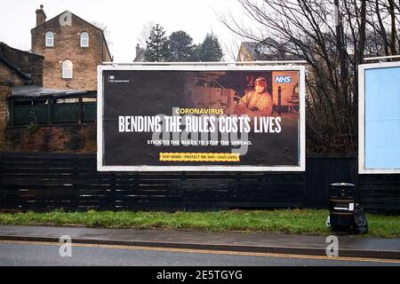 Eine Regierung und National Health Service Reklametafel Werbung über soziale Distanzierung und die Ausbreitung von Coronavirus in Shipley, West Yorkshire gesehen Stockfoto