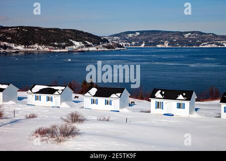 Ferienhäuser im Winter entlang des Saint Lawrence Flusses in der Nähe von Baie Sainte Catherine in der Charlevoix; Region Quebec, Kanada Stockfoto