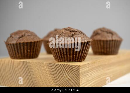 Braune Schokoladenmuffins auf Holzbrett Stockfoto