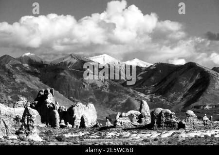 Verwitterte Sandsteinflossen, Türme, Türme und Turret Arch mit den schneebedeckten La-Sal Bergen im Hintergrund in Schwarz und Weiß Stockfoto