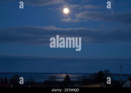 Insel Fehmarn, Deutschland. Januar 2021. Das Licht des Vollmondes erleuchtet die Fehmarnsundbrücke. Kredit: Frank Molter/dpa/Alamy Live Nachrichten Stockfoto