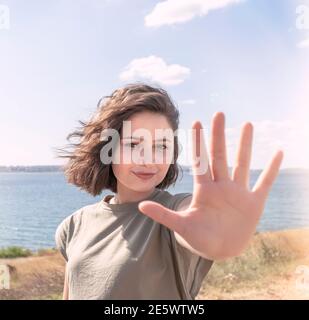 Schöne glückliche junge Frau machen Stop-Zeichen mit ihrer Hand. Stockfoto