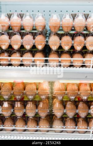 Eier in Kunststofftabletts auf Regalen im Supermarkt Stockfoto