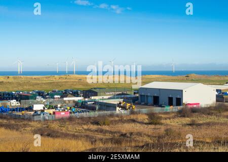 Eine Recycling-Anlage im Warrenby Light Industrial Estate Redcar Cleveland North Yorkshire England mit Windfarm und Golfplatz Hinter Stockfoto